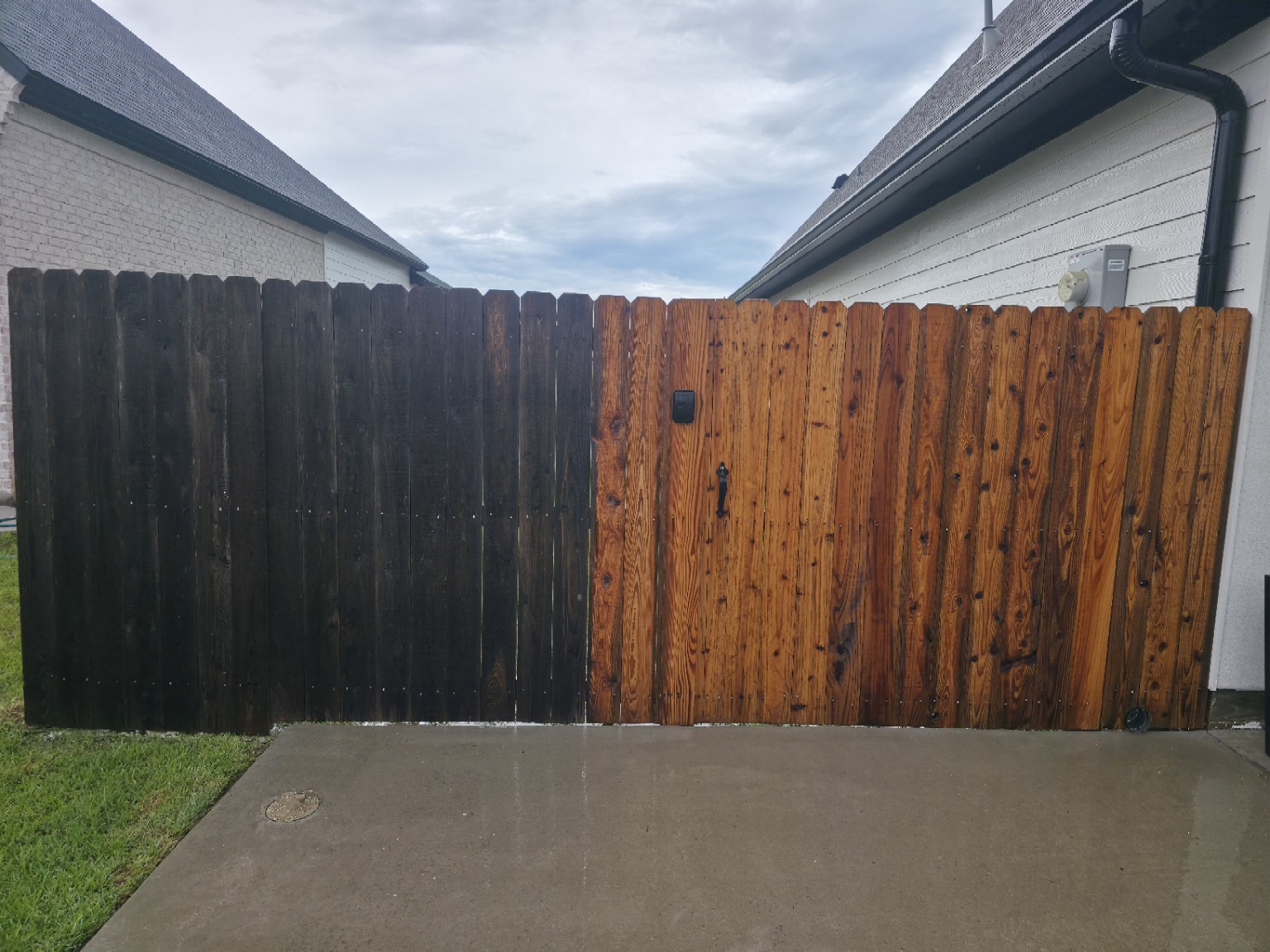 Fence cleaning in progress, with weathered wood on the left and a freshly cleaned section on the right